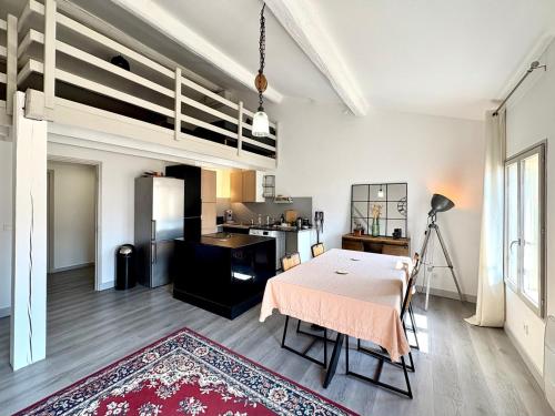 un salon avec une table et une cuisine dans l'établissement Duplex proche des Arènes, à Nîmes