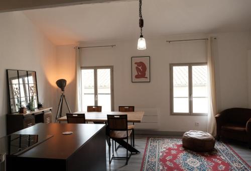 un salon avec une table et des chaises de salle à manger dans l'établissement Duplex proche des Arènes, à Nîmes