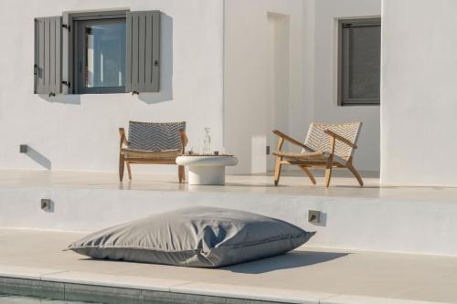 a pillow on the floor in a room with two chairs at Sunrise Poem Estate - 16 people capacity in Prodromos Paros