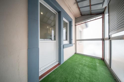 une pièce vide avec un sol vert et des fenêtres dans l'établissement Super Appartement Near Basel 4 personnes 7, à Saint-Louis