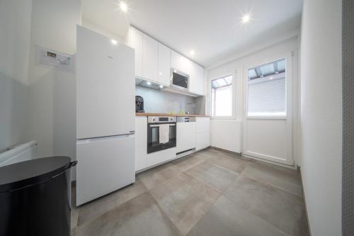 une cuisine blanche avec des appareils électroménagers blancs et une fenêtre dans l'établissement Super Appartement Near Basel 4 personnes 7, à Saint-Louis