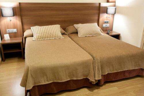a bedroom with a large bed with two pillows at BS Capitulaciones in Santa Fe