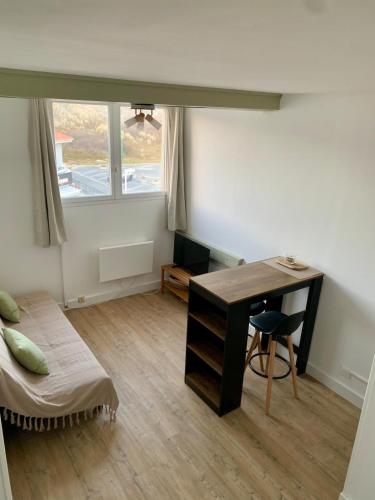 - une chambre avec un bureau, un lit et une fenêtre dans l'établissement Appartement La case a vent, à Fort-Mahon-Plage