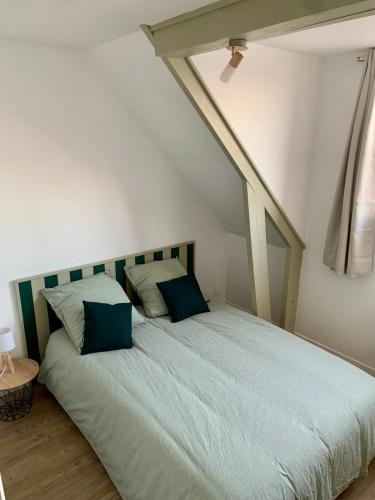 une chambre avec un grand lit avec des oreillers bleus dans l'établissement Appartement La case a vent, à Fort-Mahon-Plage