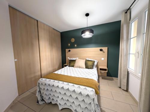 ein Schlafzimmer mit einem Bett und einer grünen Wand in der Unterkunft Appartement cosy Vue Mer et Montagne in Sari Solenzara