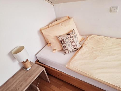 a small bedroom with a bed and a lamp at Hotel Lindenhof in Rödermark