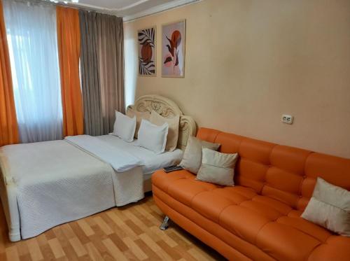 un soggiorno con un divano e un letto di Звёздный Спутник ad Aqtöbe
