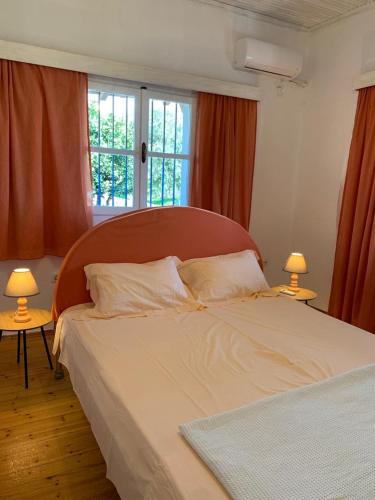 a bedroom with a large bed with two lamps at Mani Seaside Home in Agios Nikolaos