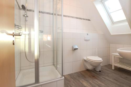 a bathroom with a shower and a toilet and a sink at Brise8 - Greetsiel in Krummhörn