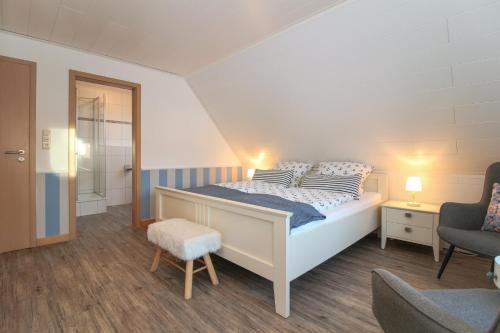 a bedroom with a bed and a chair at Brise8 - Greetsiel in Krummhörn