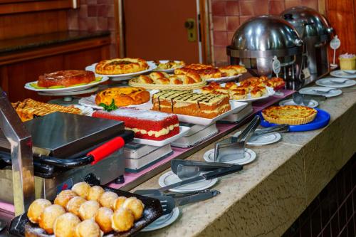 a buffet with many different types of cakes and pies at Hotel Pan Americano in Sao Paulo