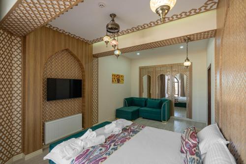 a hotel room with a bed and a tv at Volidam Hotel in Samarkand