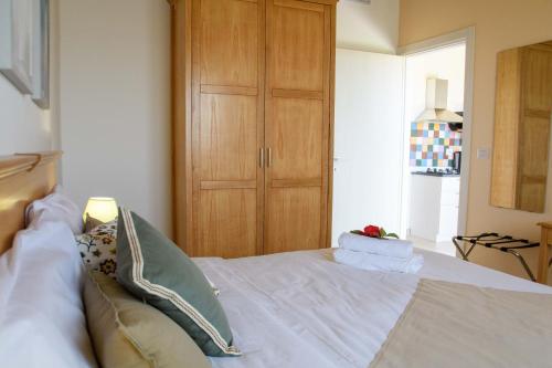 a bedroom with a white bed with a wooden cabinet at Stella del Rio in Naro