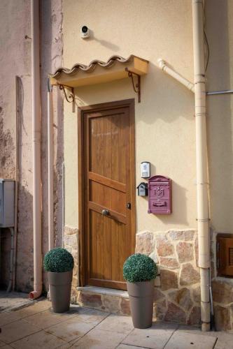 a wooden door on a building with two plants at Sunshine Apartments in Trappeto