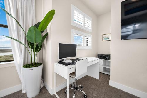 a room with a desk with a computer and a plant at Modern 3br Lake House In Rowlett in Rowlett