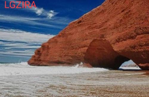 a large rock in the water next to the ocean at Maison pres plus Grand Bazar d'Afrique Souk El Had in Agadir