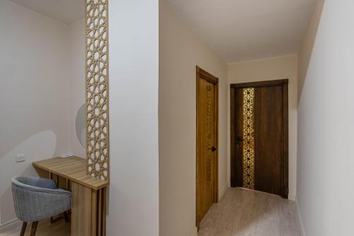 a hallway with a wooden door and a chair at Volidam Hotel in Samarkand