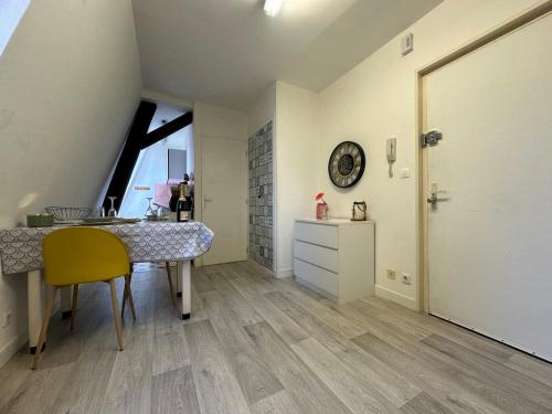 a kitchen with a table and a yellow chair at Calvaire charmant studio rénové proche gare in Sedan