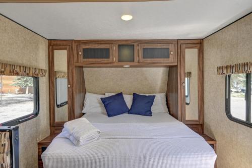 a bed in an rv with blue pillows at Snowy Peaks RV Park in Buena Vista
