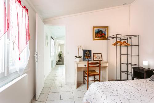 une chambre avec un lit et un bureau avec une chaise dans l'établissement Maisonnette centre ville, à La Rochelle