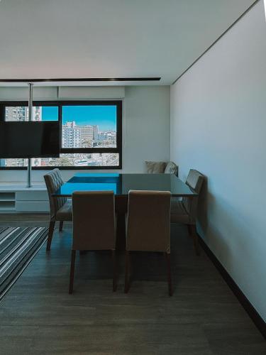 a dining room with a table and chairs and a tv at GO Rio Branco by LikeHome in Porto Alegre