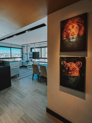 a living room with two paintings of lions on the wall at GO Rio Branco by LikeHome in Porto Alegre