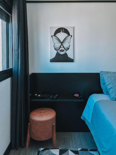 a bedroom with a bed and a chair and a picture at GO Rio Branco by LikeHome in Porto Alegre