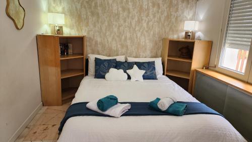 une chambre avec un lit avec des oreillers bleus et blancs dans l'établissement Villa de vacances avec Piscine, Billard & Pétanque, à Saint-Georges-de-Didonne