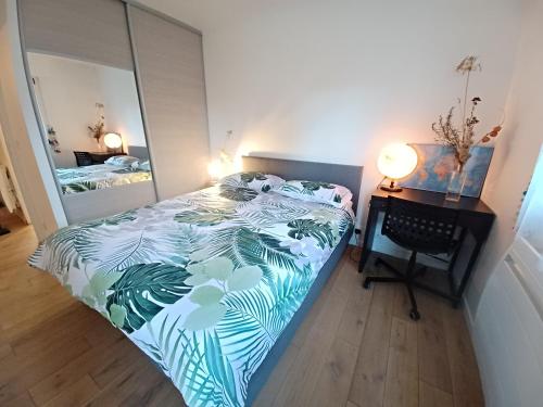 Un dormitorio con una cama, un escritorio y un espejo. en 2 beds, modern building, with mobile AC, Paris Expo, 7' metro 2 steps to Paris, en Montrouge