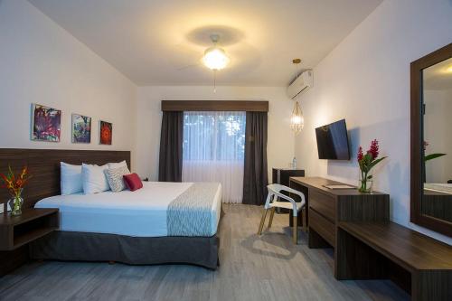 a hotel room with a bed and a mirror at Mesón de la Luna Hotel & Spa in Mérida