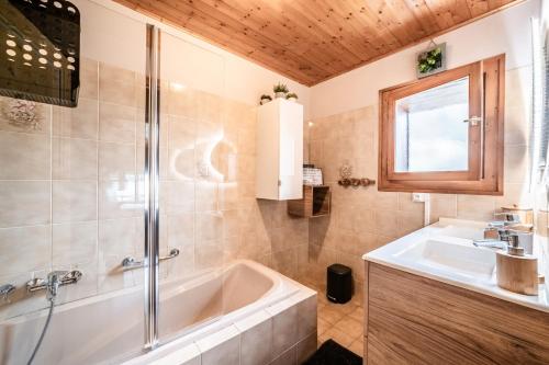 a bathroom with a tub and a sink at Gite La Ferme de la plaigne in Taninges