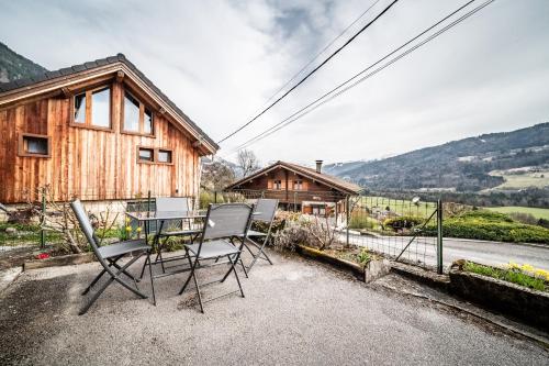 a table and chairs in front of a house at Gite La Ferme de la plaigne in Taninges