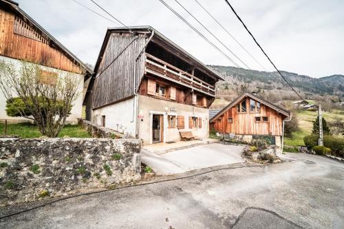 an old house with a building on the side of it at Gite La Ferme de la plaigne in Taninges