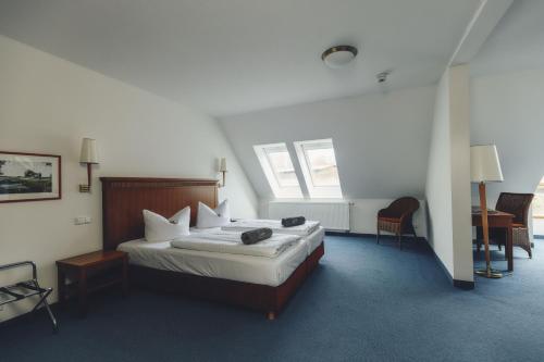 a hotel room with a bed and a desk at Seehotel Heidehof in Klein Nemerow