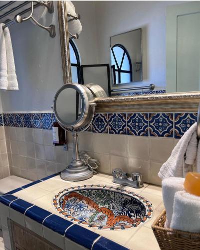 a bathroom with a sink and a mirror on a counter at Hacienda del Lago Boutique Hotel in Ajijic