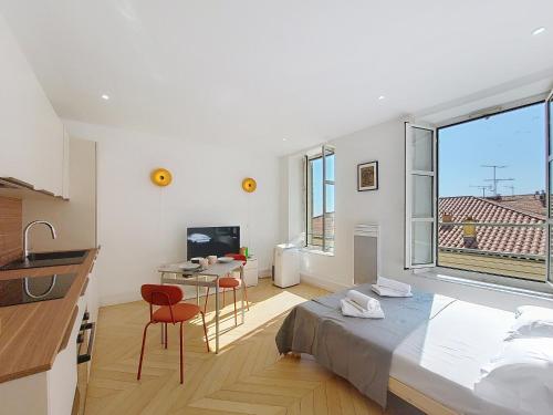 une chambre avec un lit et un bureau et une cuisine dans l'établissement Nestor&Jeeves - STUDIO DU PORT - Central, à Nice