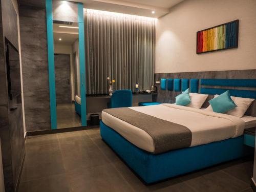a hotel room with a bed and a bathroom at Hotel Grand Sudhan in Thanjāvūr