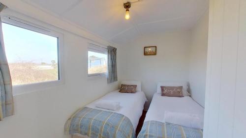 two beds in a small room with a window at G17 St Meva, Riviere Towans in Hayle