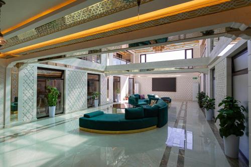 a large living room with a couch and a tv at Volidam Hotel in Samarkand