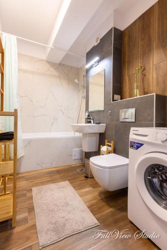 a bathroom with a sink and a washing machine at FullView Studio DeLuxe, PLUS Free Underground Parking in Timişoara