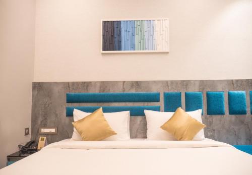 a bedroom with a bed with a blue headboard at Hotel Grand Sudhan in Thanjāvūr