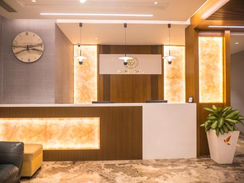 a lobby with a reception desk and a clock at Hotel Grand Sudhan in Thanjāvūr