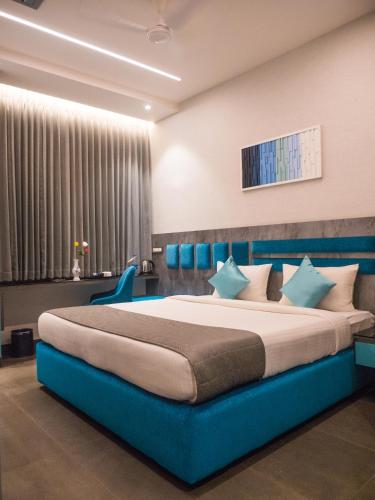 a bedroom with a blue bed in a room at Hotel Grand Sudhan in Thanjāvūr