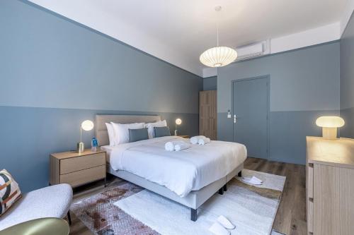 - une chambre bleue avec un grand lit et un canapé dans l'établissement Opera # Louvre # PalaisRoyal # Académiefrançaise # AC, à Paris