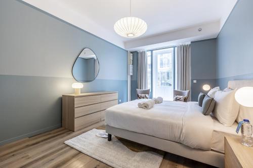 une chambre avec un grand lit et un miroir dans l'établissement Opera # Louvre # PalaisRoyal # Académiefrançaise # AC, à Paris