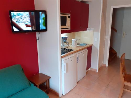 a kitchen with a tv hanging on the wall at Superbe duplex in Monflanquin