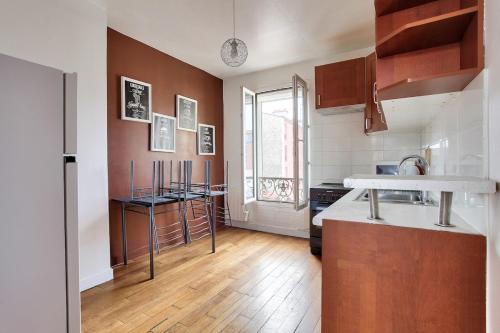 Il comprend une cuisine dotée de parquet et d'un comptoir. dans l'établissement Cocon calme et lumineux - Clichy, à Clichy