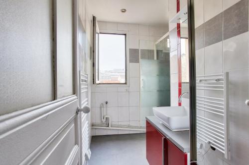 une salle de bain avec un lavabo et des toilettes et une fenêtre dans l'établissement Cocon calme et lumineux - Clichy, à Clichy
