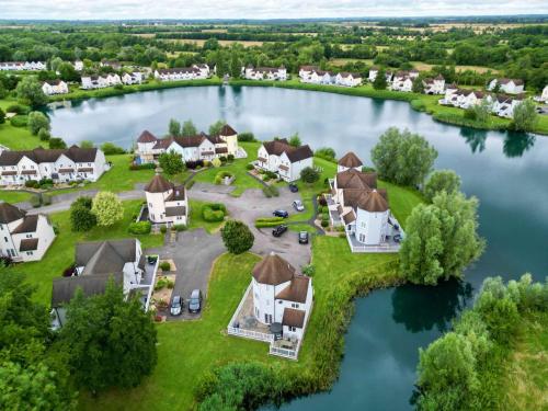 an aerial view of a home on a lake at Windrush Turret Lodge in South Cerney
