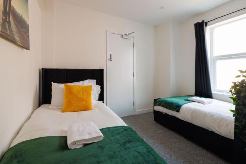 a bedroom with two beds and a window at 4 Bedroom, Sleeps 8, 3 Bathroom, Hot Tub, WiFi, Smart TVs in Each Room 3 min walk to KINGSHOLM Stadium in Gloucester